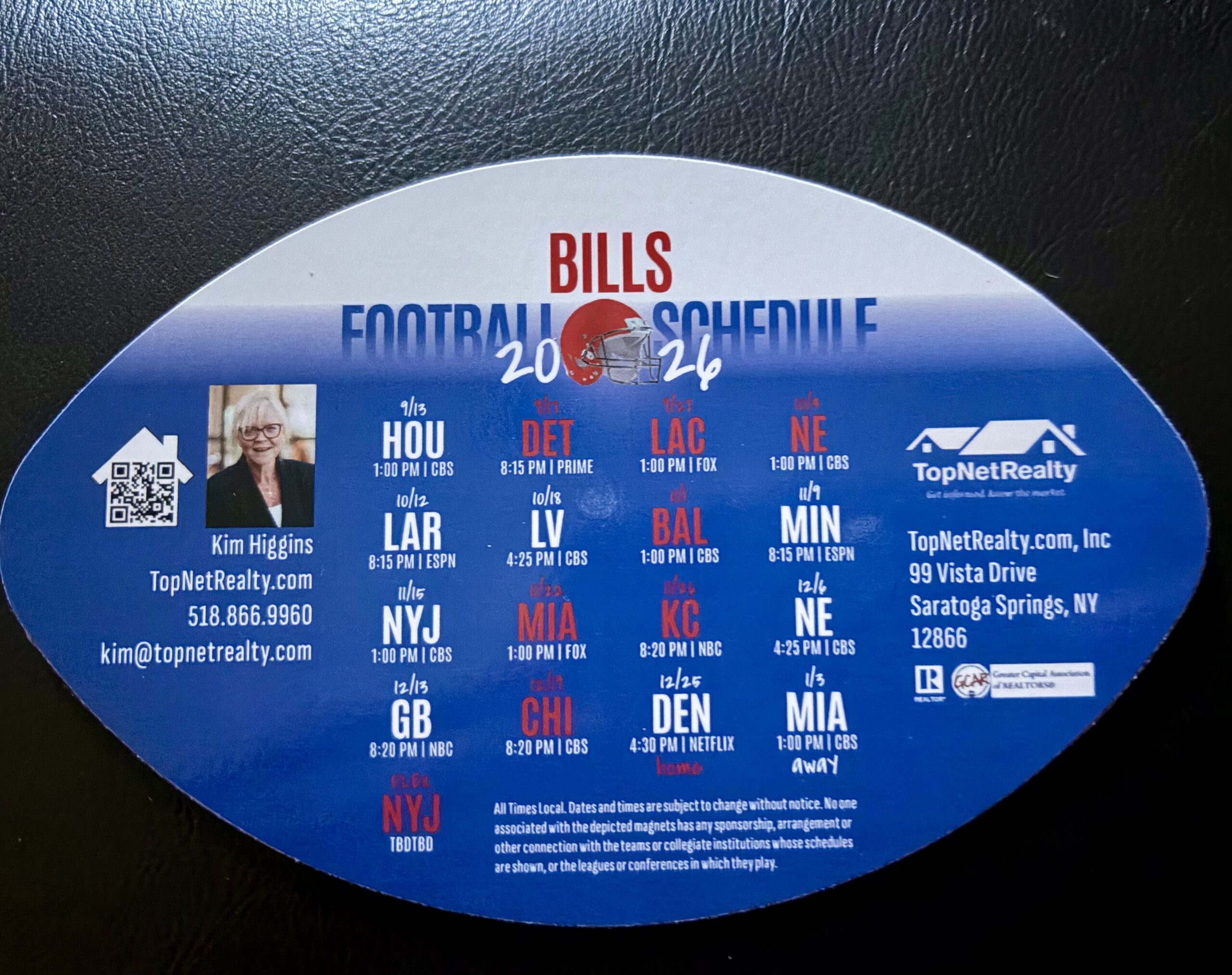 Football-shaped Bills 2026 schedule magnet with Kim Higgins’s portrait, contact information and TopNetRealty branding.
