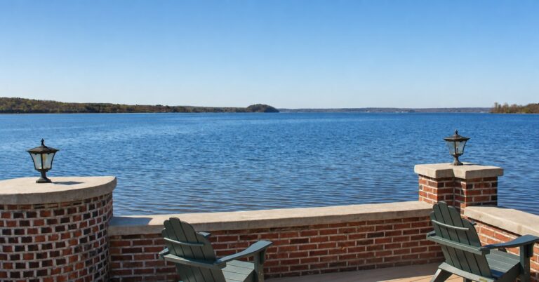 Saratoga Lake viewed from the Water’s Edge/Woodlands terrace, with two lamps and Adirondack chairs in the foreground.