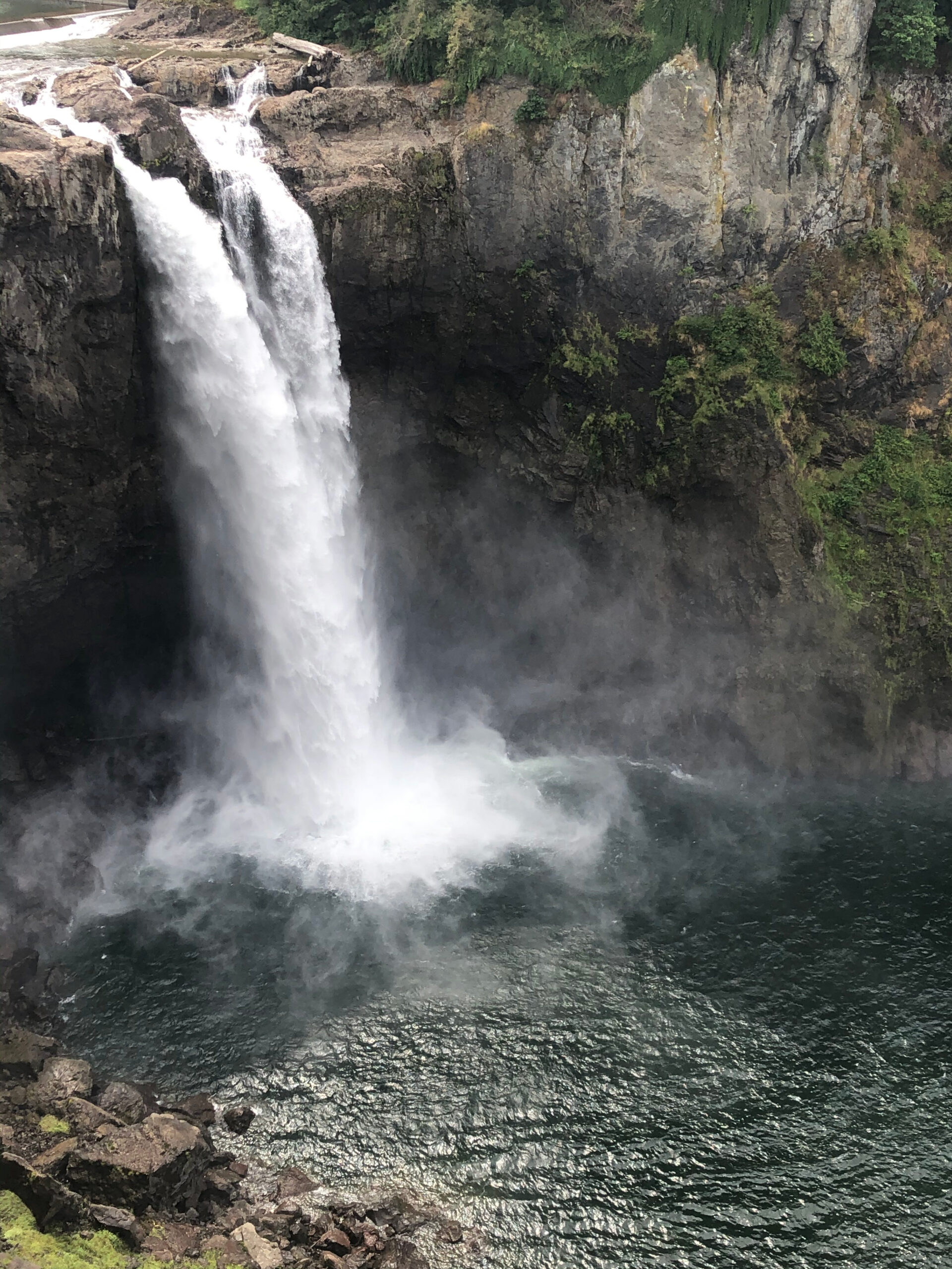 Snoqualmie Falls cascading over rocky cliffs into the river below in Washington.