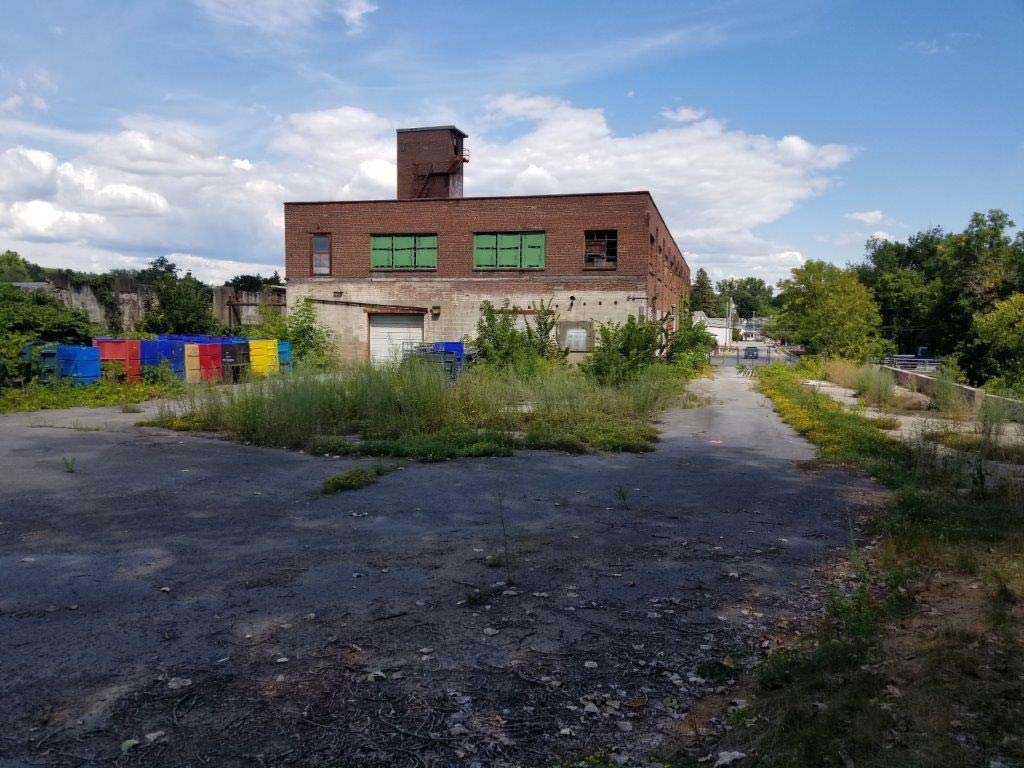 Brick industrial building and paved yard at the former tannery property at 125 Bath Street, as shown in the filed applicant presentation.